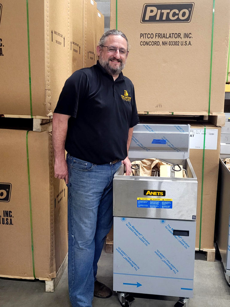 Jon Sondheimer with restaurant equipment in warehouse